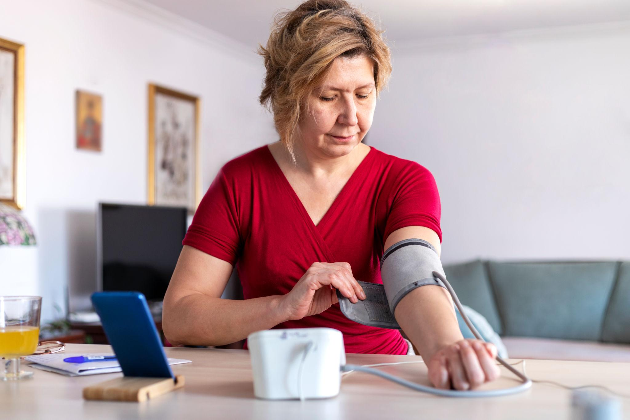Adult checking blood pressure with a home monitor